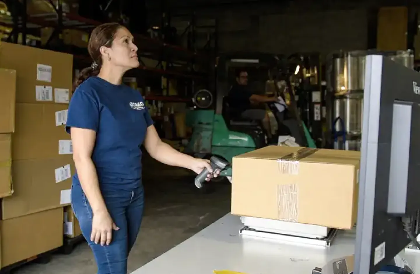 A warehouse worker using a parcel dimensioner.