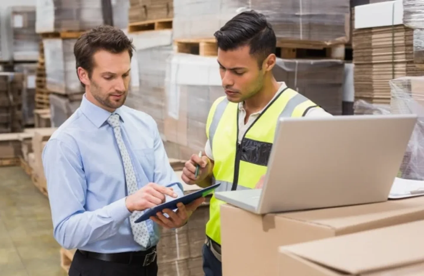 Warehouse manager and employee discussing order processing metrics.