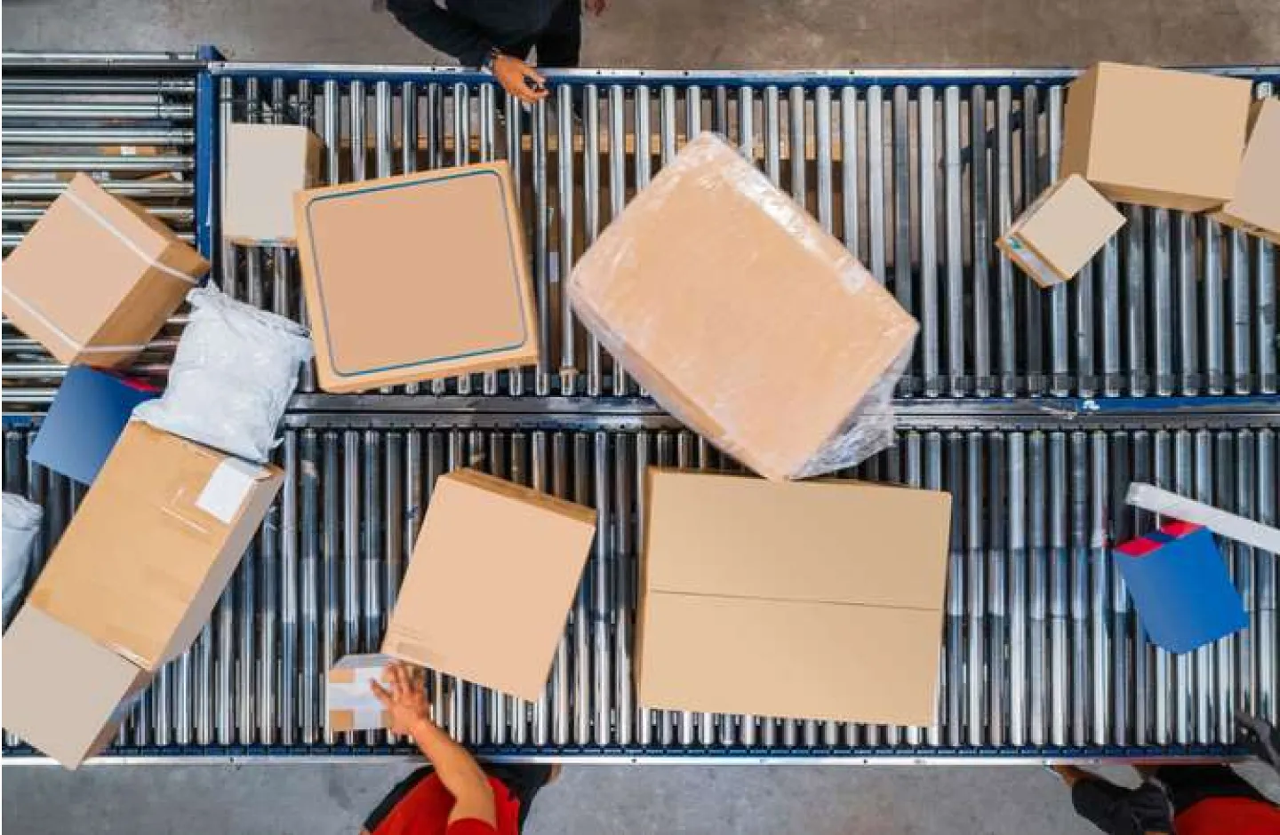 A warehouse conveyor with employees during operation. Top view.